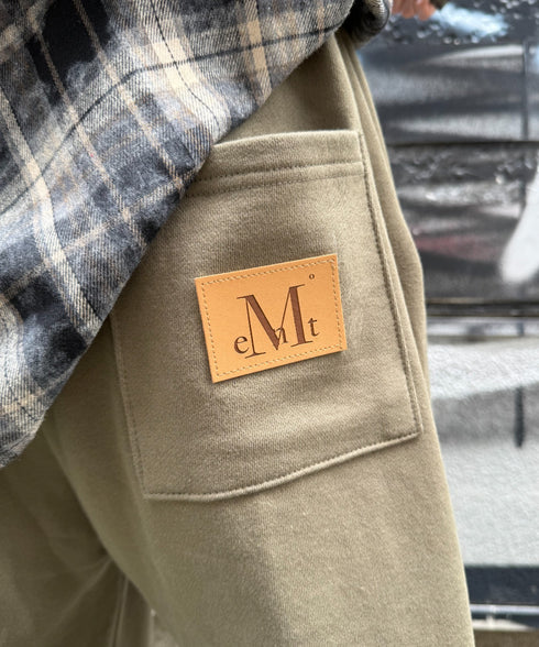 MUCENT(ムセント)/ユニセックス ワイド ルーズ ロゴ ジョガー スウェットパンツ/LASH METAL LOGO JOGGER SWEAT WIDE PANTS UNISEX | AT2252030 | カーキ