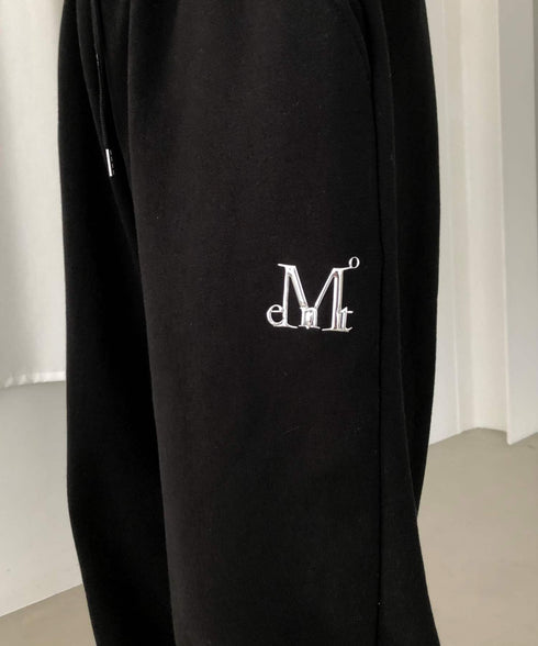 MUCENT(ムセント)/ユニセックス ワイド ルーズ ロゴ ジョガー スウェットパンツ/LASH METAL LOGO JOGGER SWEAT WIDE PANTS UNISEX | AT2252030 | ブラック